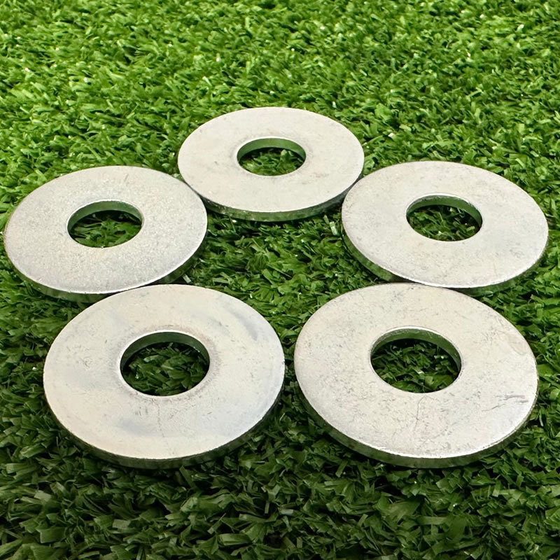 Five conical washers on green. Hardware components for industrial applications.